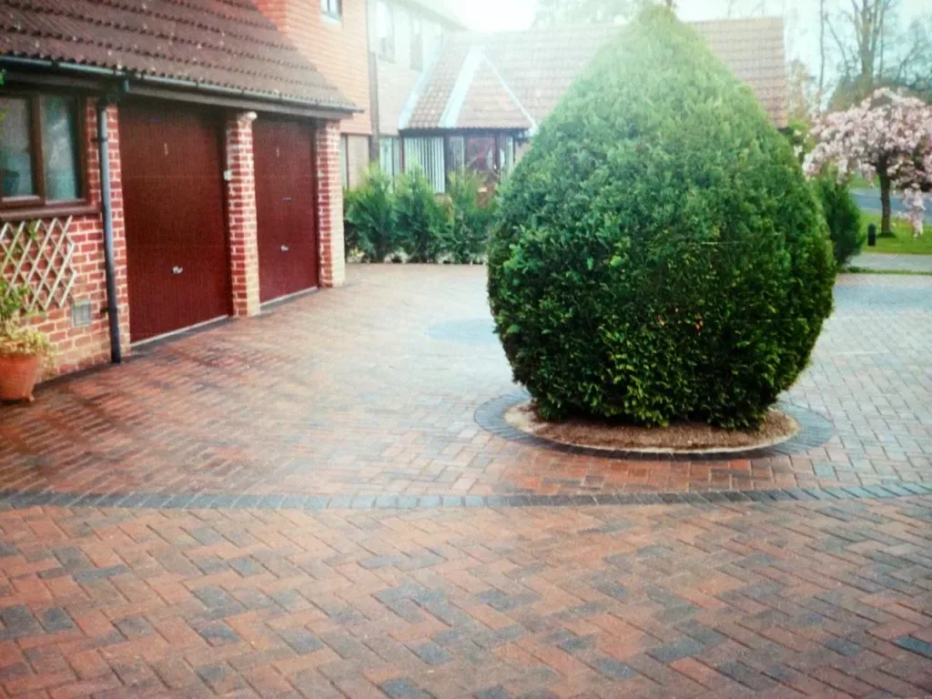 Wide block paved driveway with parking for several cars