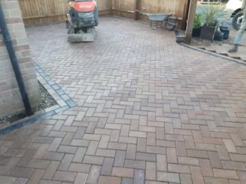 Small block paved patio area finished with a brick border