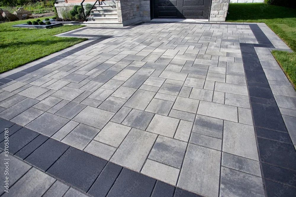 Grey block paving laid in a linear pattern with a dark charcoal border