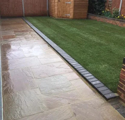 Indian sandstone patio with a clean edge against a lawn