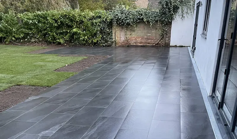 Dark grey porcelain patio slabs laid outside a set of bi-fold doors