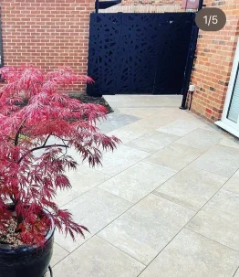 Grey porcelain garden terrace beside planted borders