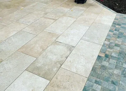 Grey porcelain patio laid across a landscaped rear garden