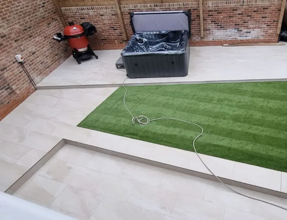 Porcelain paving terrace with a lawn edge and planted borders