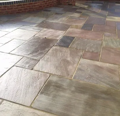 Porcelain patio finished neatly against a garden wall