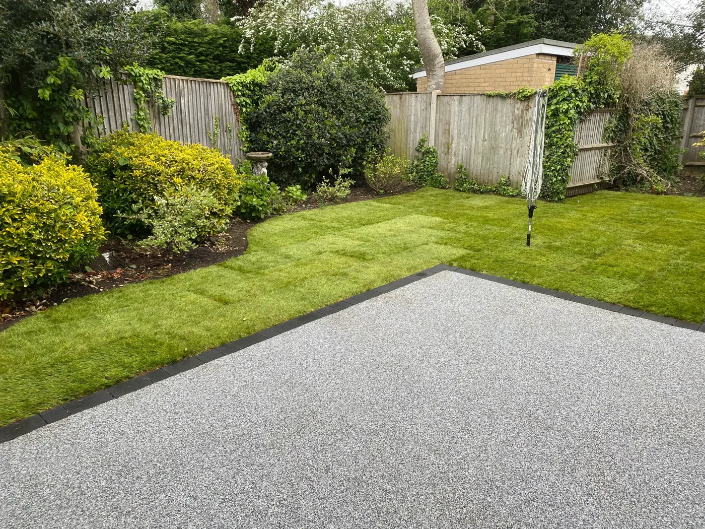 Resin bound surfacing edged cleanly against a lawn